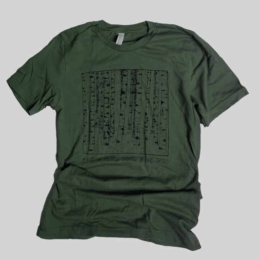 dark green screen pinted t shirt with a line art illustration of a birch forest. under the image is the text A Lot of People Hiding Behind Trees